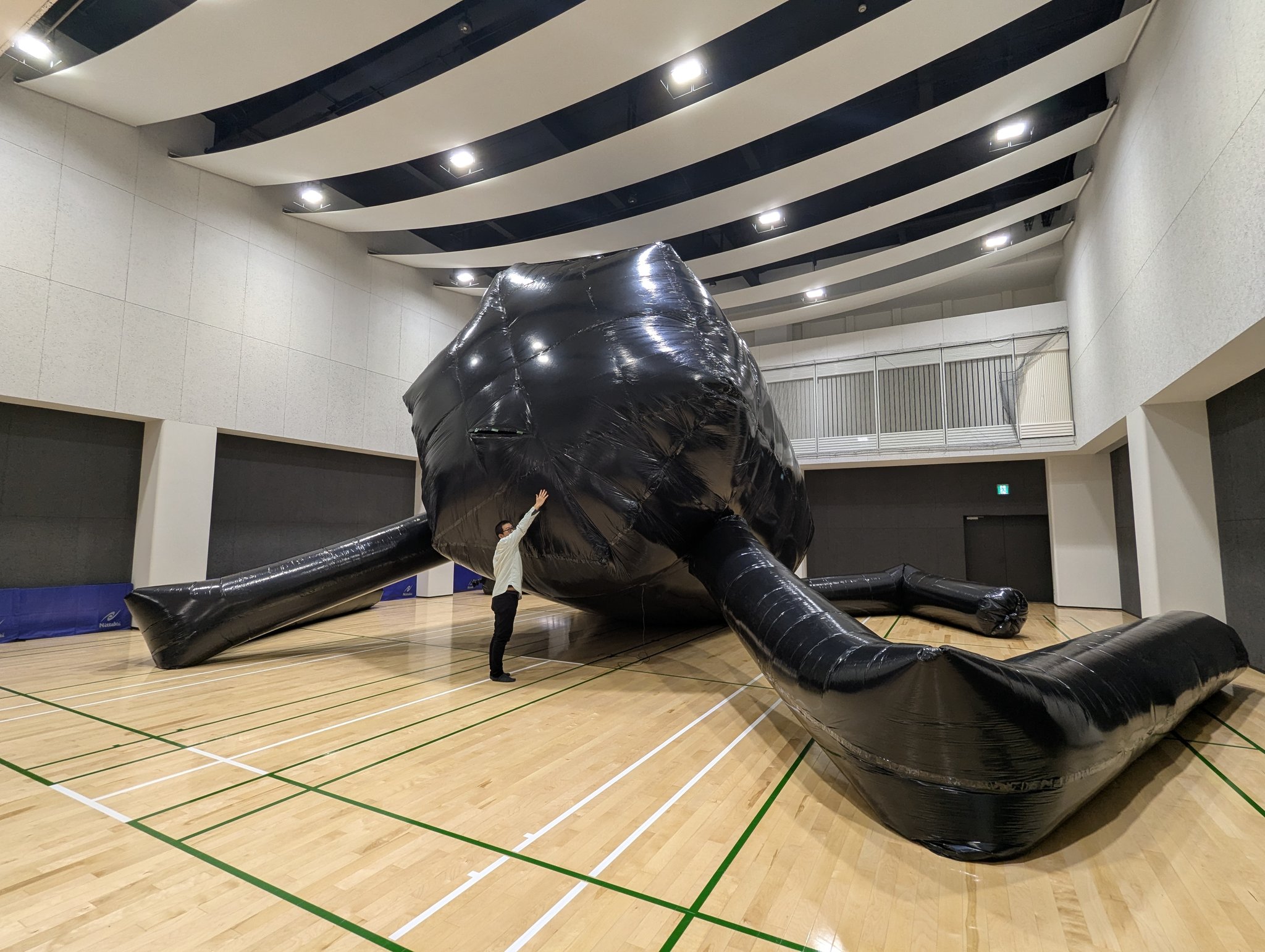 体育館で制作中の巨大セルリアン。大きさを比較するために人が手を伸ばしている